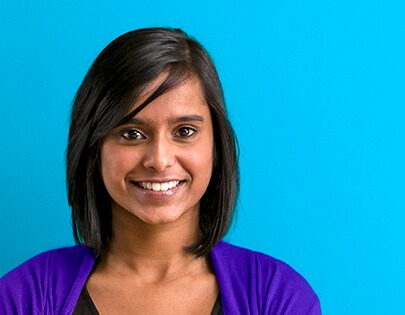 Uma mulher sorrindo diante de um fundo azul.